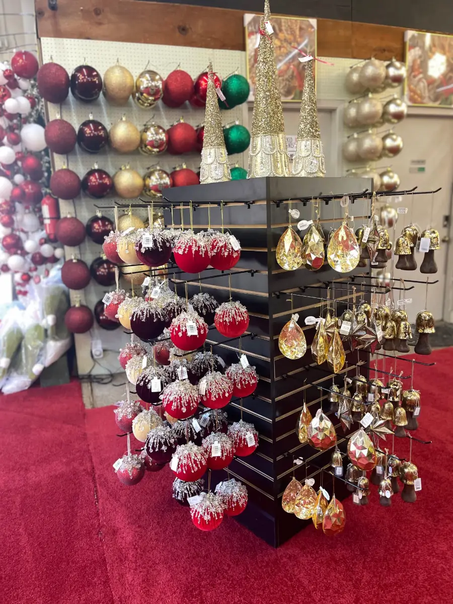 Racks of red, gold and burgundy Christmas ornaments at Candy Cane Corner
